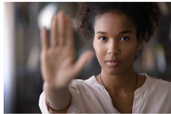 Woman with dark hair holds hand out.