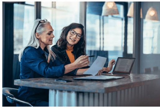 Two women working together on a laptop.