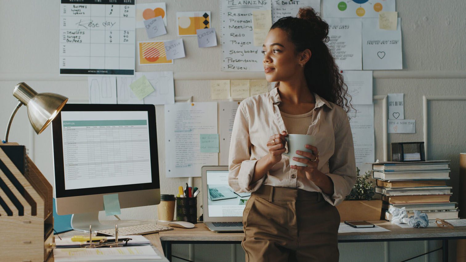 Woman in office holding a cup of coffee.